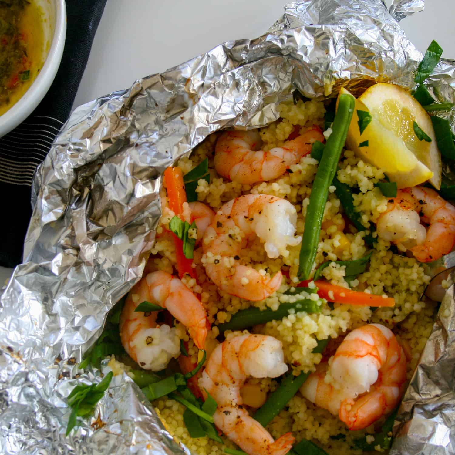 Are you ready to try something new? Give these easy, 30 minute, all-in-one foil wrapped dinners a go. Shrimp with fresh vegetables & seasoned cous cous all smothered in parsley, lemon and garlic sauce and tightly wrapped (to seal in that flavour) in individual foil packets.