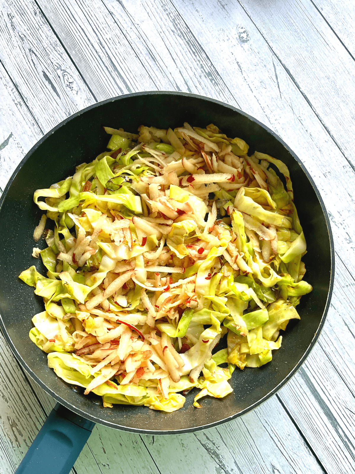 cabbage in a pan with grated apple 